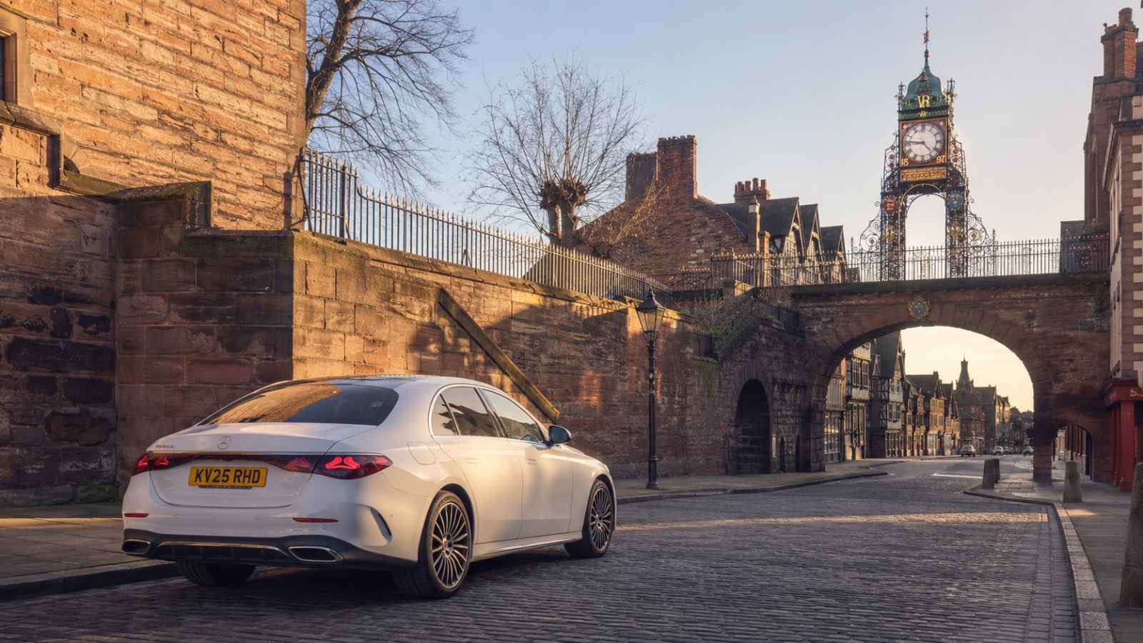 Executive saloon taxi at Chester at dawn on route to Manchester Airport, historic city architecture in background