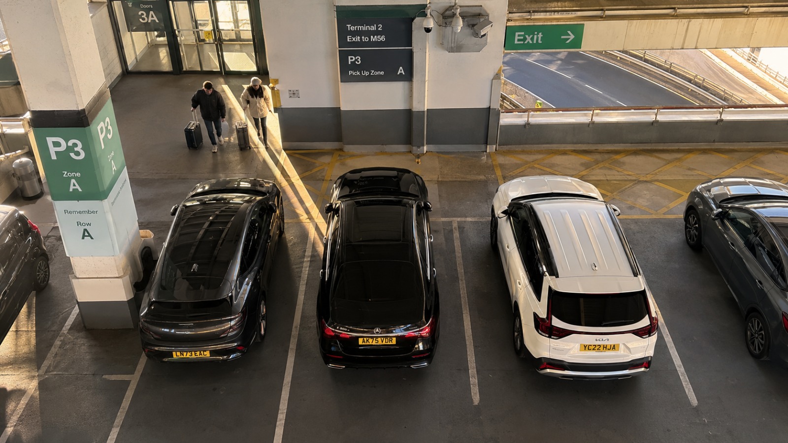 Aerial view of Mercedes saloon arriving at Manchester Airport Terminal 2 P3 rush hour from Liverpool