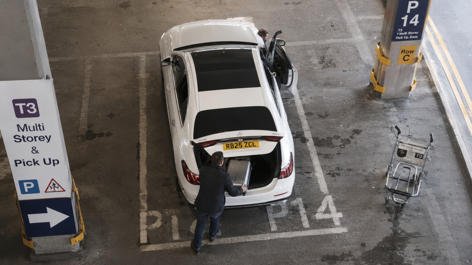 Overhead view of taxi at Manchester Airport Terminal 3 P14, driver loading Wrexham traveller suitcase