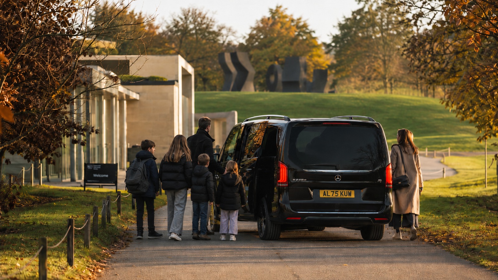 Family boarding 8-seat minibus at Yorkshire Sculpture Park entrance for Manchester Airport transfer